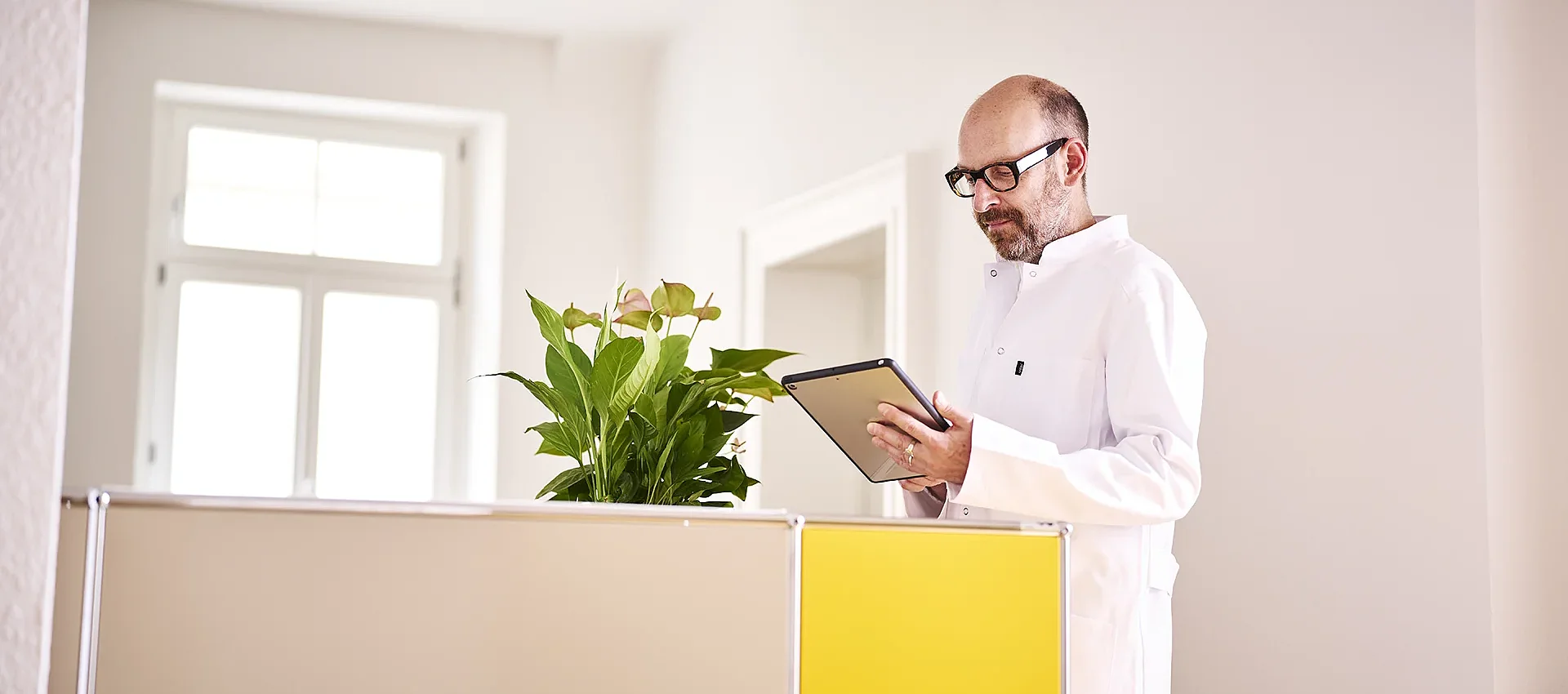 Prof. Dr. Sven Poli mit Tablet in der Praxis Neuropoli